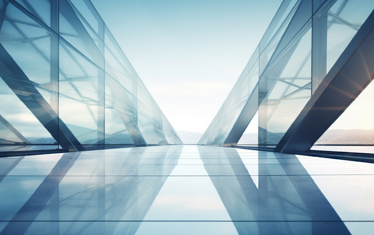 Modern glass architectural corridor with reflective surfaces and a bright, open horizon.